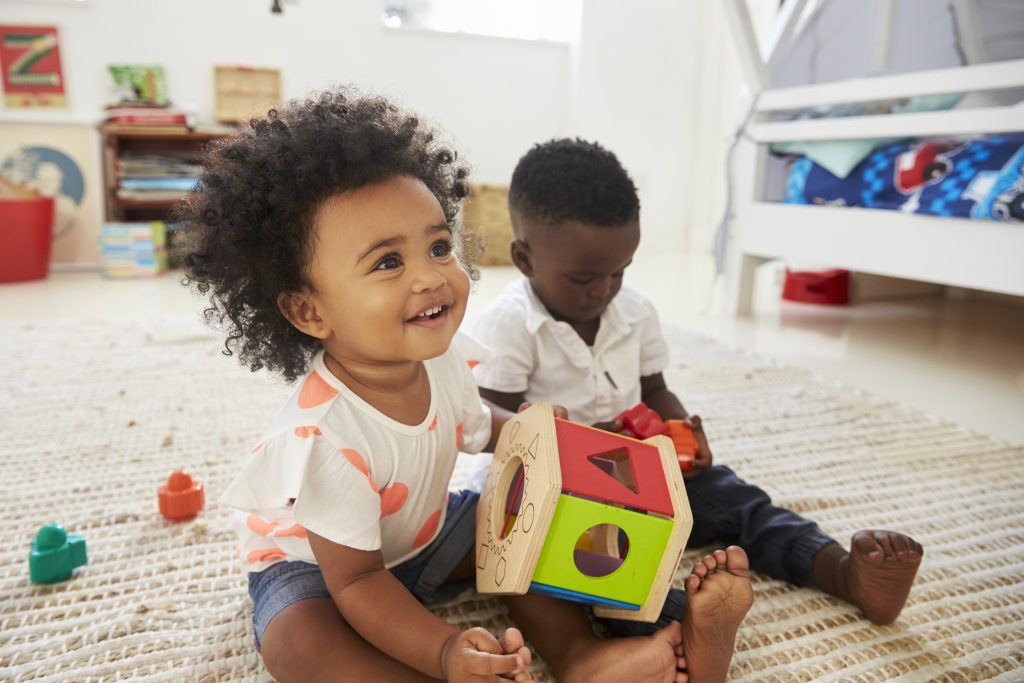 Close-up of a baby girl and boy playing with toys together